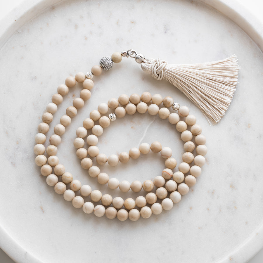 Beige Quartz tasbih (misbaha) with 99 natural beige quartz beads, silver separators and a cream tassel on white marble