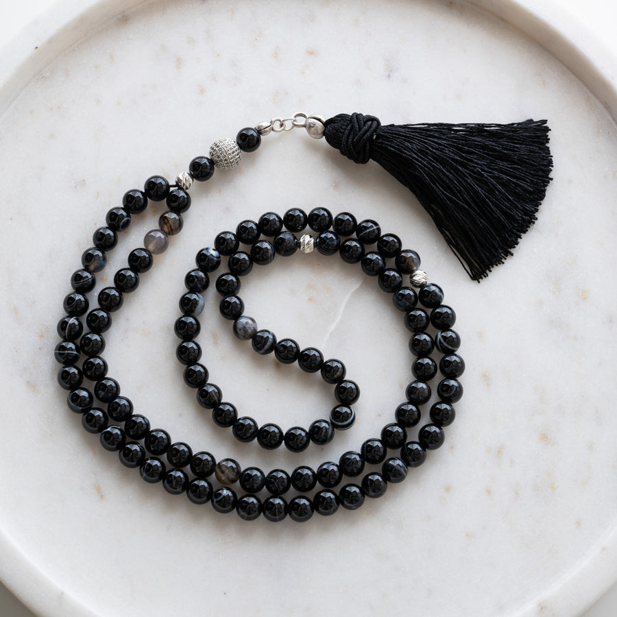 Black Agate tasbih (misbaha) with 99 natural black agate beads, silver separators and a black tassel on white marble