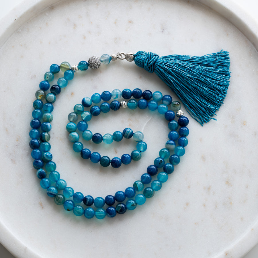 Blue Agate tasbih (misbaha) with 99 natural blue agate beads, silver separators and a blue tassel on white marble