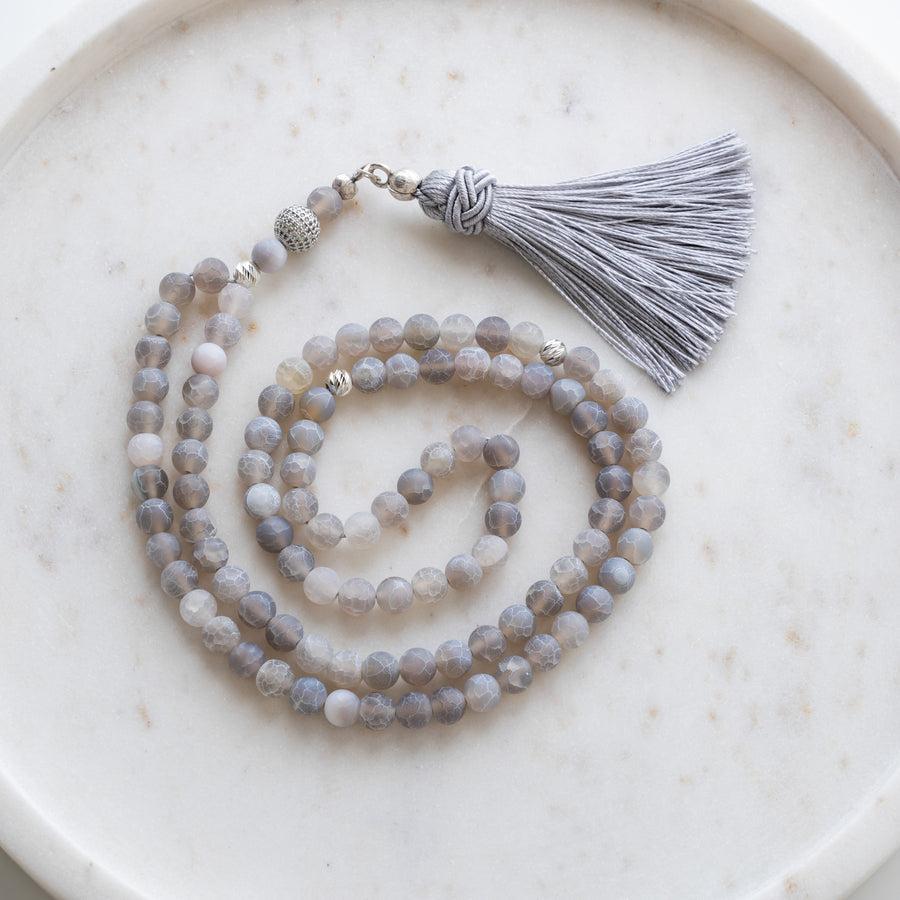 Grey Matte Agate tasbih (misbaha) with 99 natural grey matte agate beads, silver separators and a grey tassel on white marble