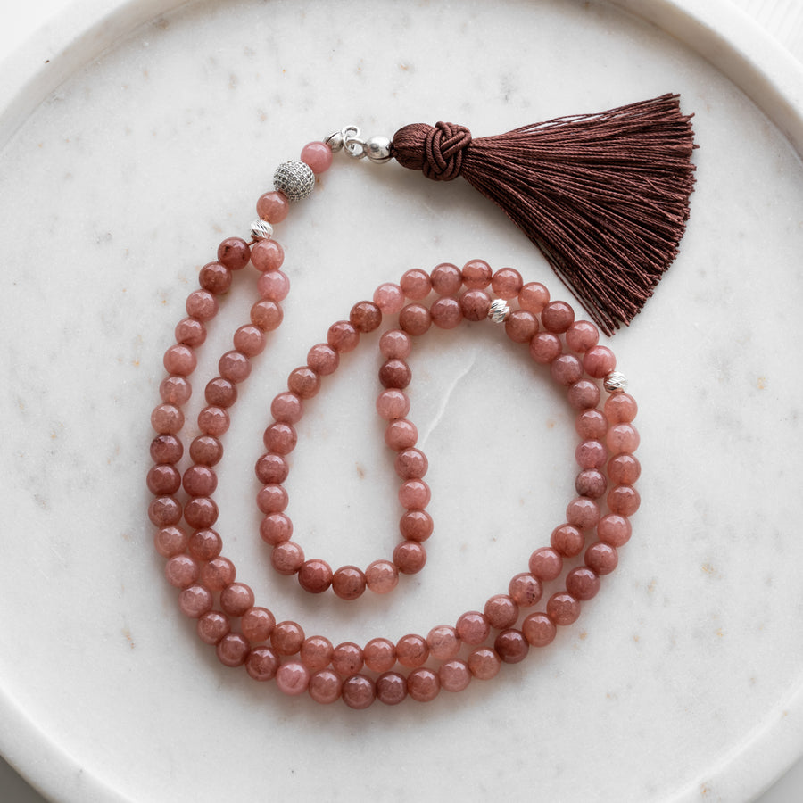 Pastel Rose Quartz tasbih (misbaha) with 99 natural pastel rose quartz beads, silver separators and a brown tassel on white marble